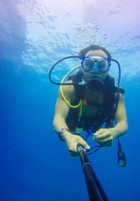 pexels-photo-347136-347136 A scuba diver explores the vibrant underwater world in Thailand, capturing the moment with a monopod.